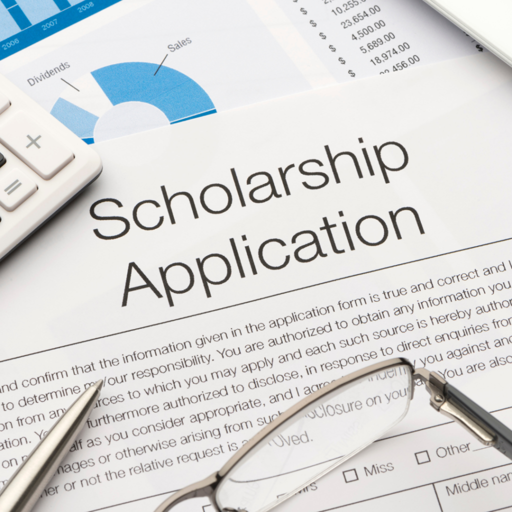 Stock photo of a scholarship application with calculator, glasses and pen.