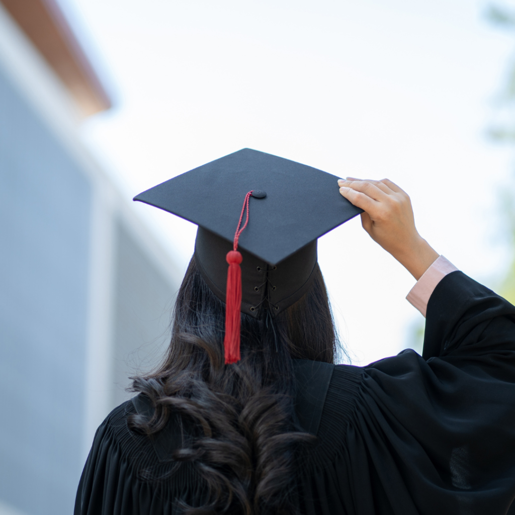 Photo of the back of a woman in a graduation cap and gown