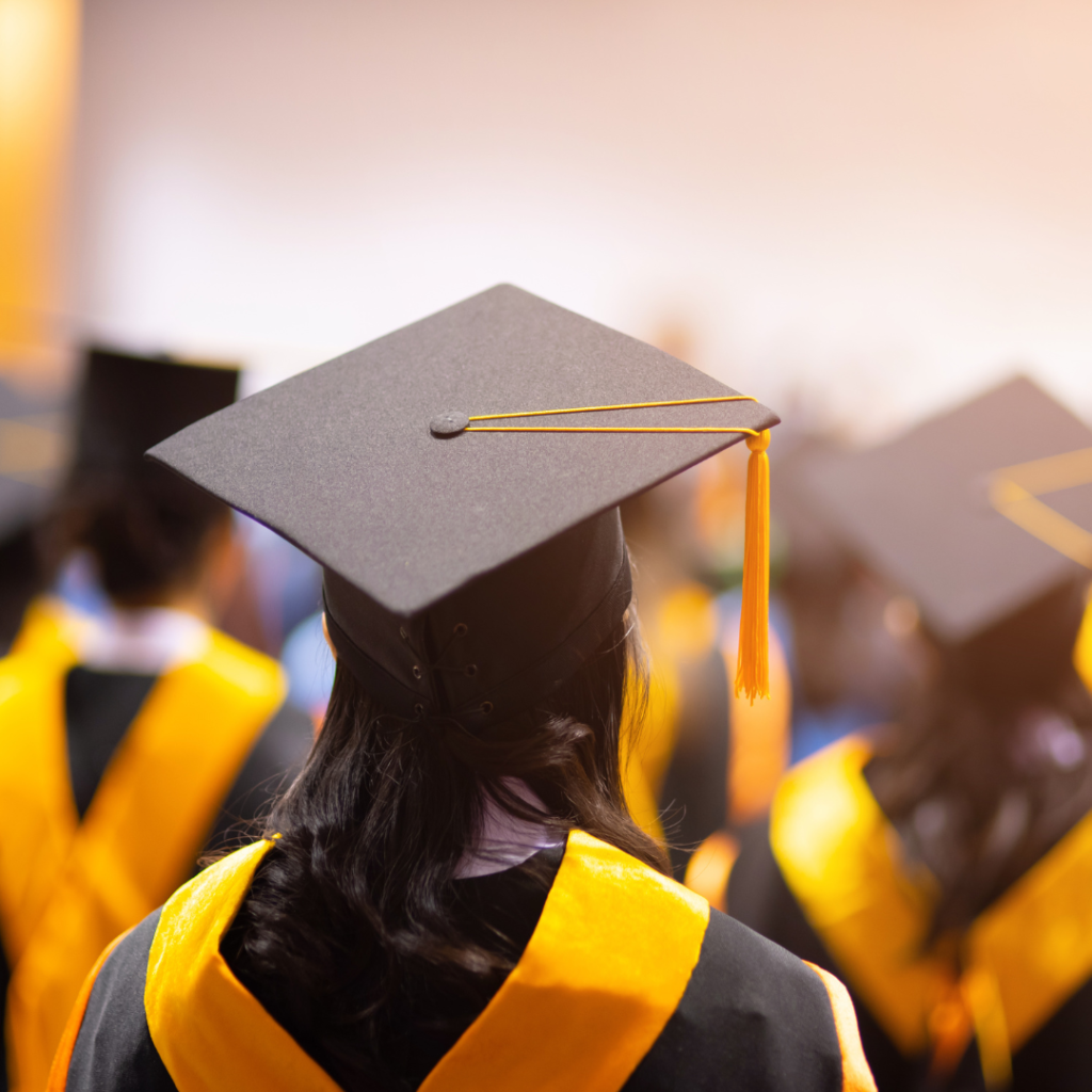 The back of a female graduate wearing a cap and gown.